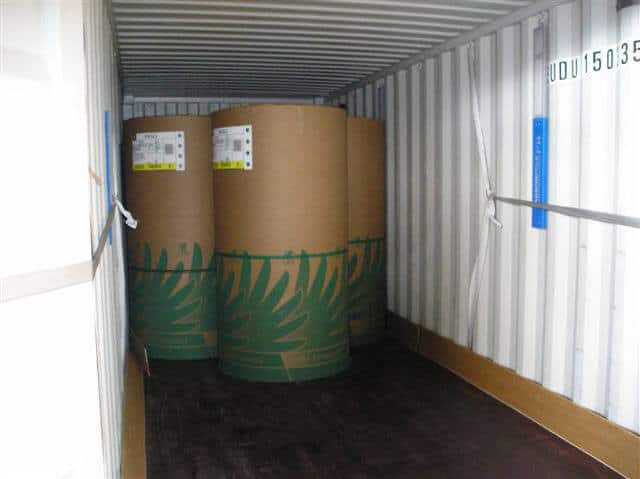 Flatboards in container protecting rolls during transport